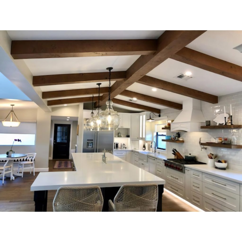 Rustic faux beams installed over a modern kitchen