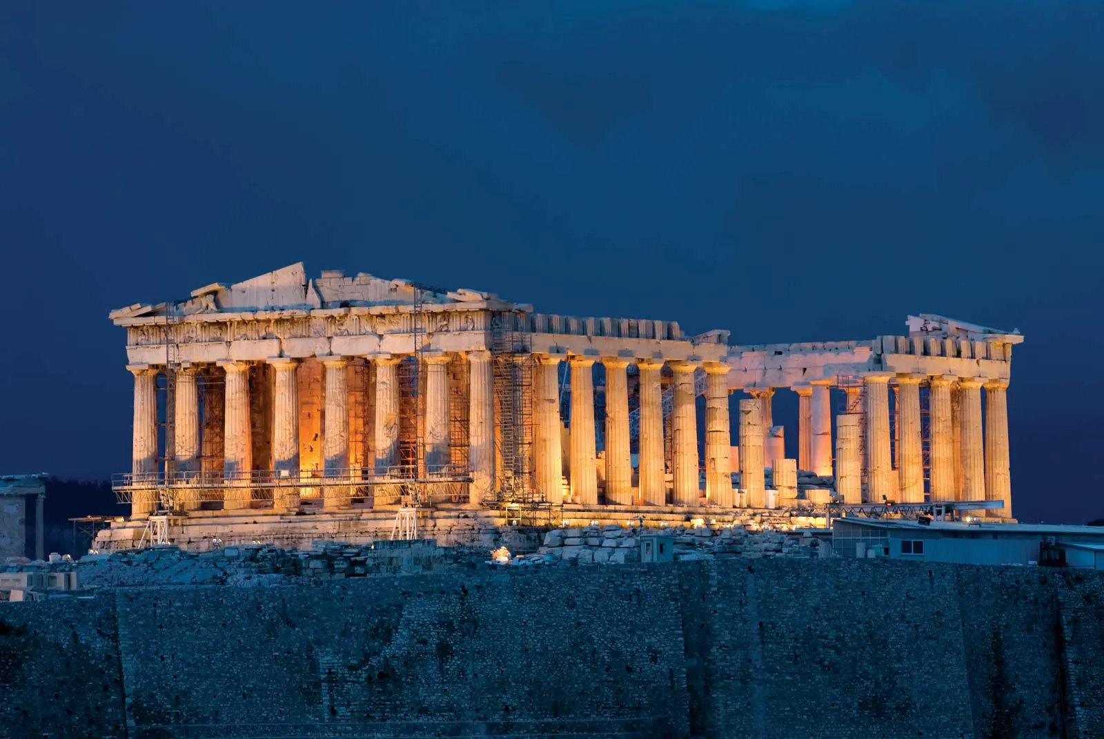 The Parthenon lit up at night, highlighting the Doric columns